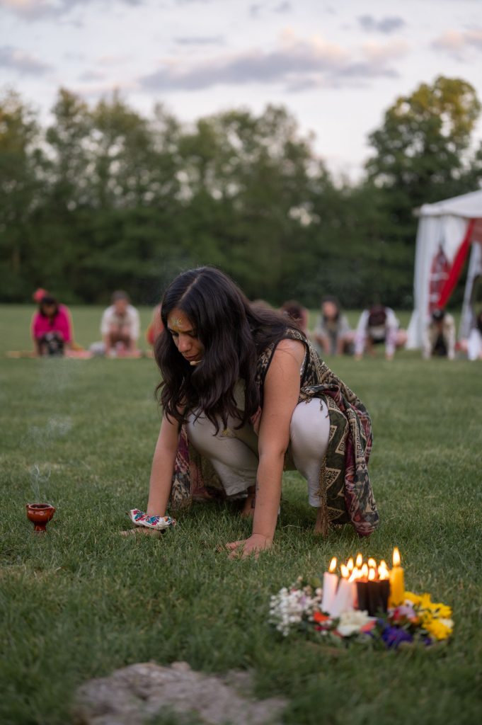 Layla, pendant une cérémonie de cacao, s'incline pour toucher la terre et la remercier